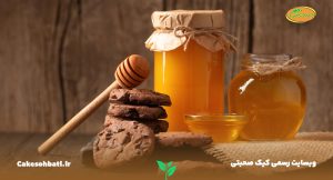 یک میز و دیوار چوبی که بر روی آن سه شیشه پر از عسل و چند کوکی تهیه شده از عسل قرار دارند که به فواید عسل اشاره می‌کنند.