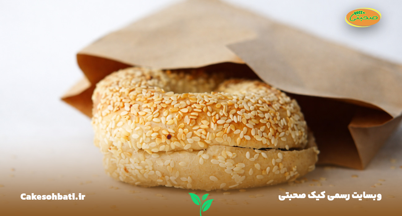 نمای نزدیک از یک کیک کنجدی بسته‌بندی که از درون پاکت نیمی از آن بیرون آمده است.